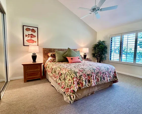 a bed sitting in a spacious bedroom next to a window