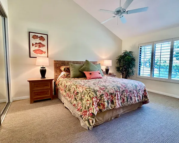 a bed sitting in a spacious bedroom next to a window