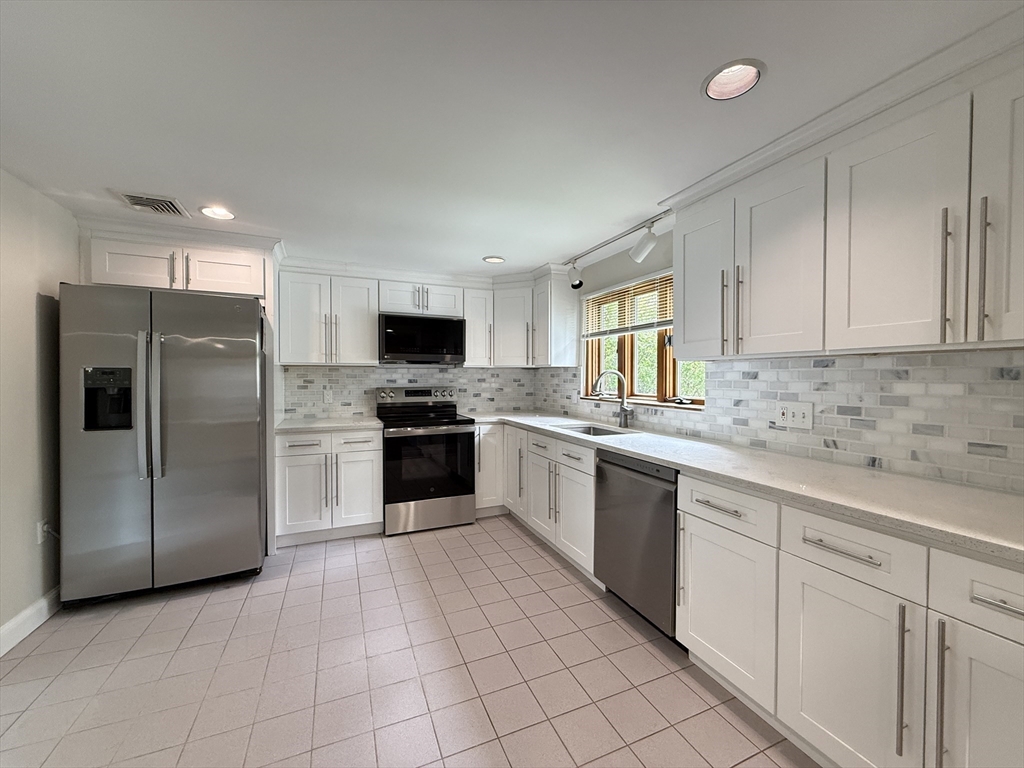 115 Grove Street Brookline, MA 02467 - Photo 2 of 12 a kitchen with cabinets and stainless steel appliances