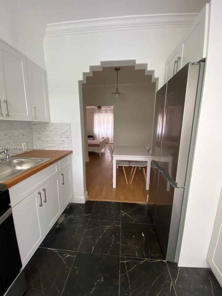 1227 Euclid Avenue, Unit 6 Miami Beach, FL 33139 - Photo 8 of 24 a kitchen with granite countertop a refrigerator and a stove top oven