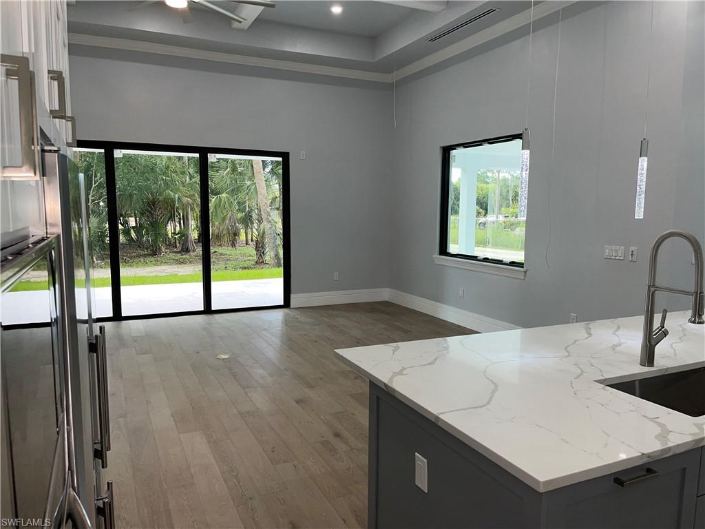 3203 68th Street Southwest Naples, FL 34105 - Photo 13 of 34 a kitchen with a sink a large window and furniture