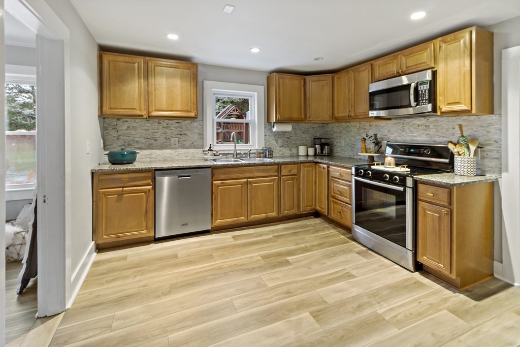 978 Point Road Marion, MA 02738 - Photo 9 of 38 a kitchen with stainless steel appliances granite countertop a stove top oven a sink dishwasher a refrigerator and a microwave oven on the granite countertops