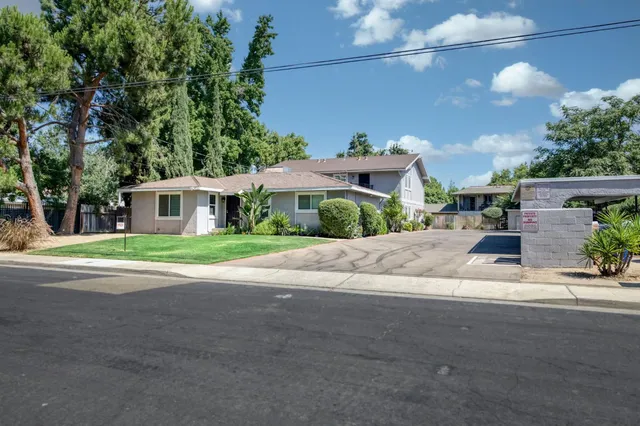 a front view of house with yard and trees around