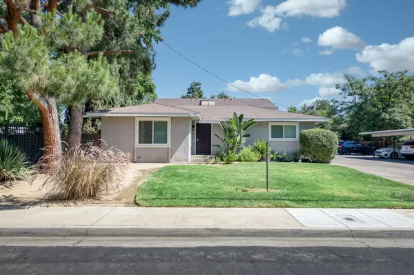 a front view of a house with a yard and potted plants