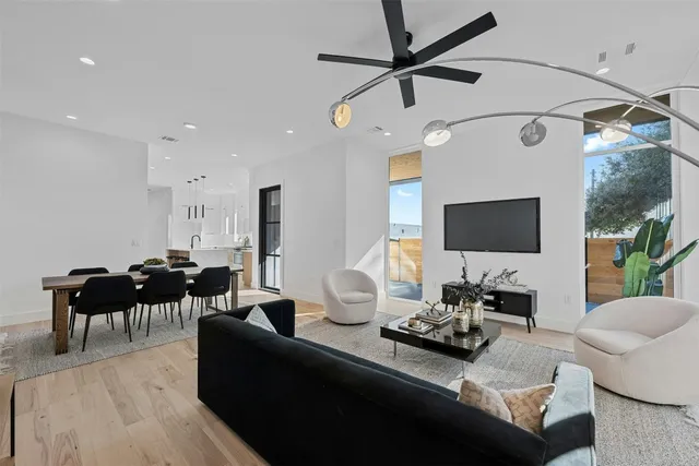 a living room with furniture a flat screen tv and a window