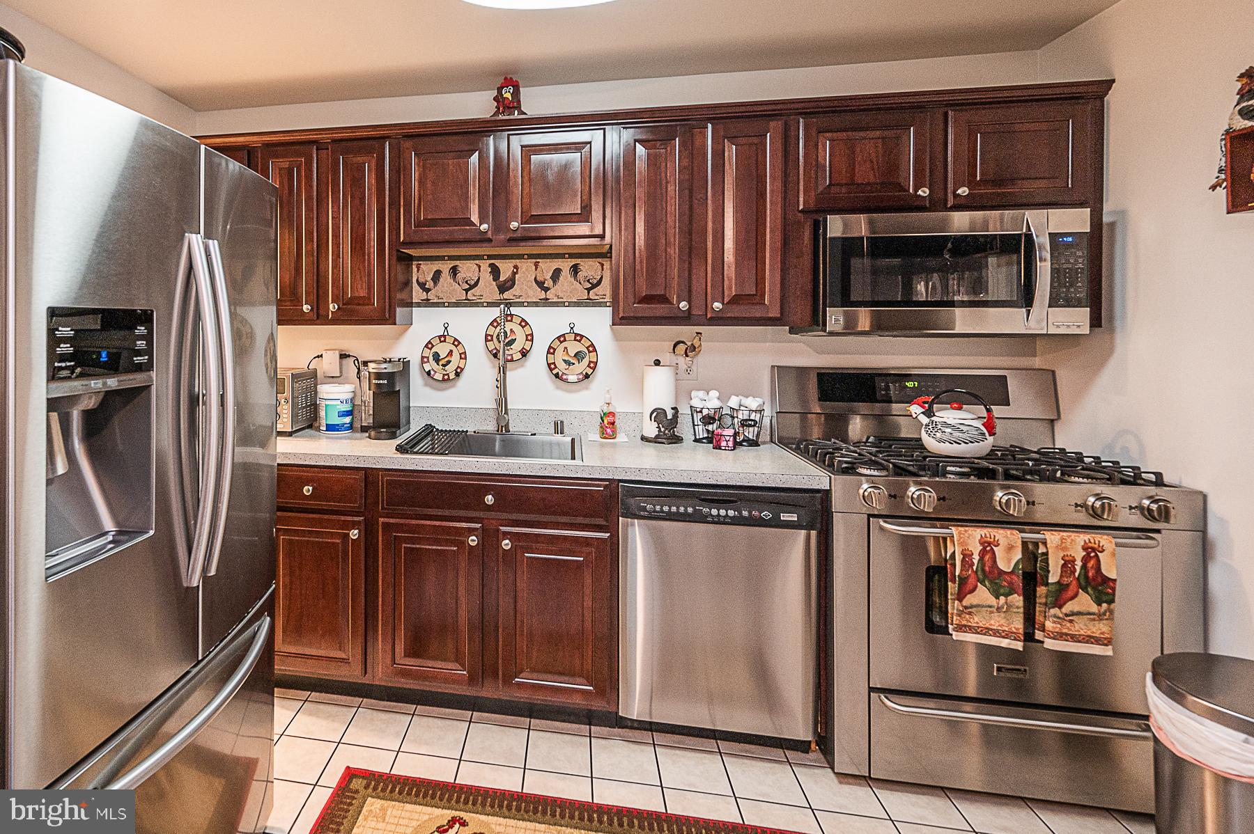 945 Middlesex Road Essex, MD 21221 - Photo 3 of 33 a kitchen with stainless steel appliances granite countertop a stove microwave and refrigerator