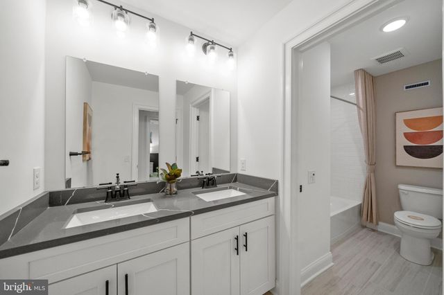 a bathroom with a granite countertop sink toilet and a mirror