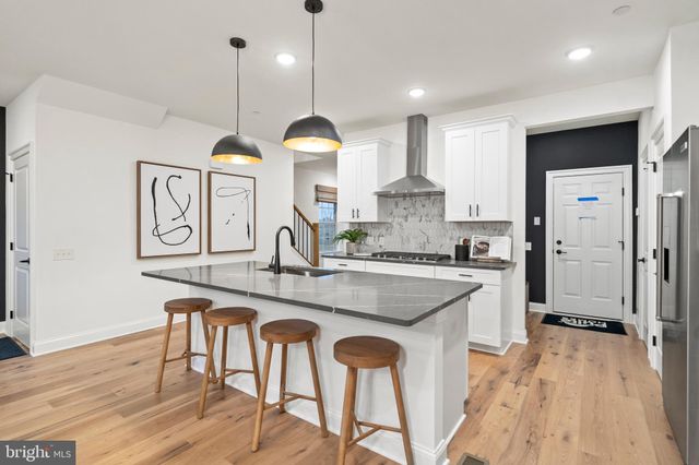 a kitchen with kitchen island granite countertop a sink a center island stainless steel appliances and cabinets