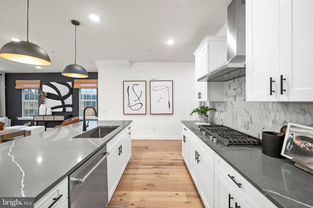 a large kitchen with stainless steel appliances granite countertop a sink a stove and a wooden floors