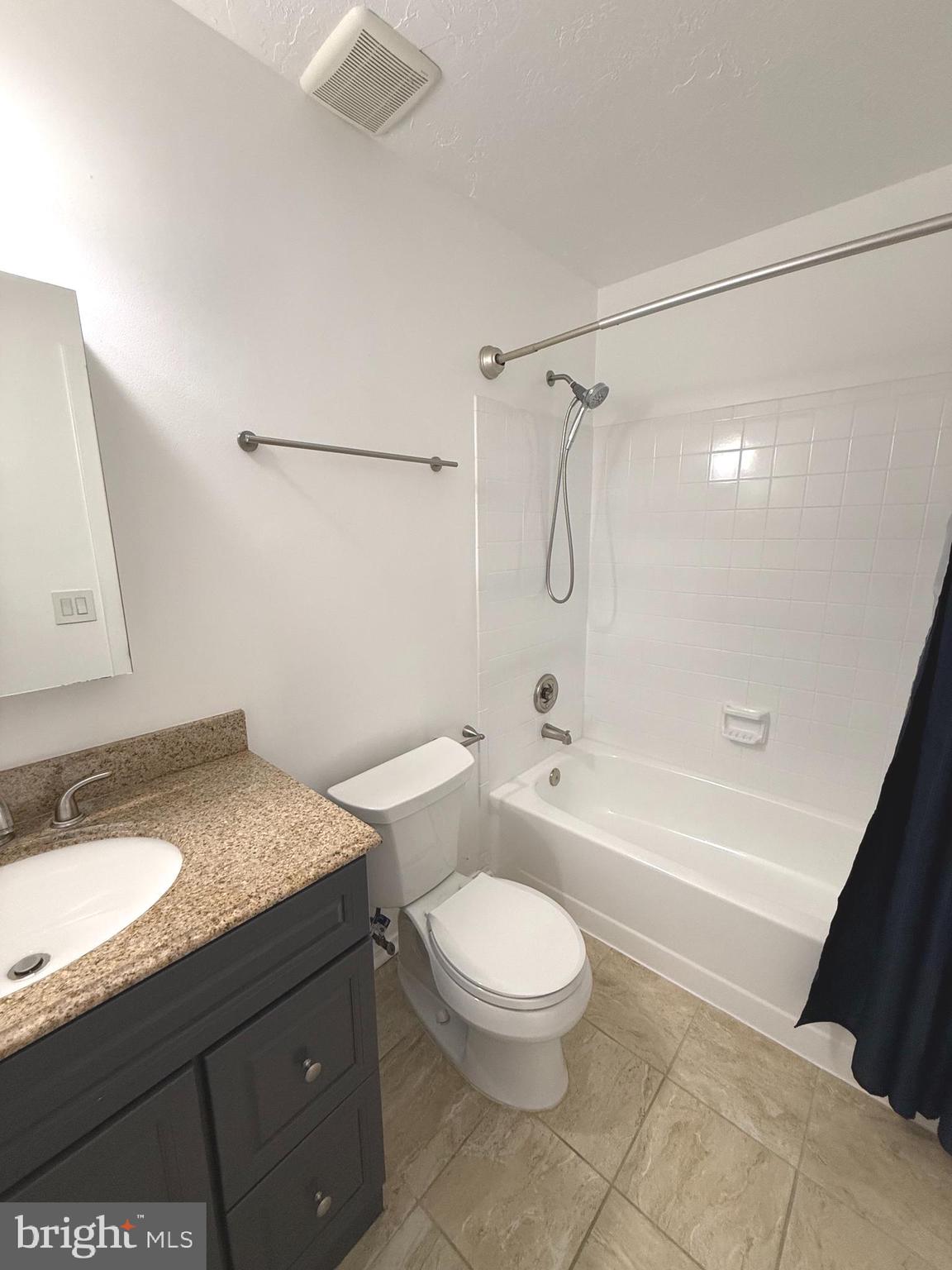 11743 Summerchase Circle, Unit B Reston, VA 20194 - Photo 8 of 25 a bathroom with a granite countertop sink toilet a mirror and a bathtub