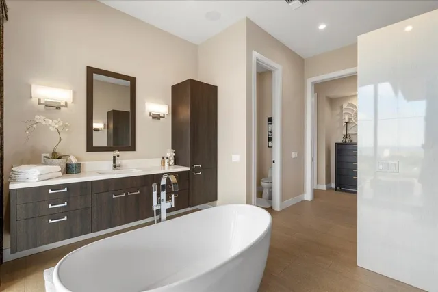 a spacious bathroom with a bathtub sink and mirror