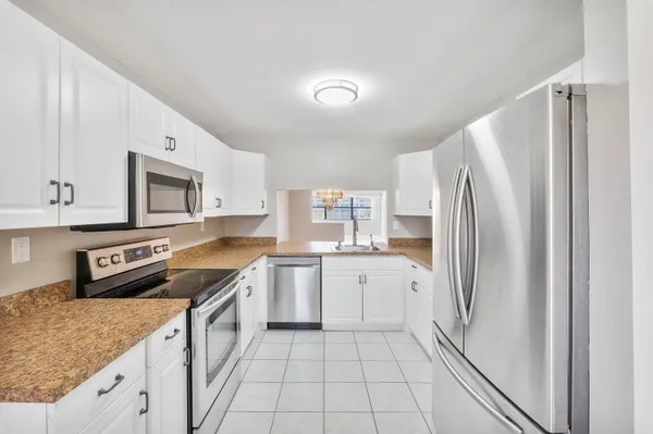 a kitchen with stainless steel appliances granite countertop a refrigerator sink and stove