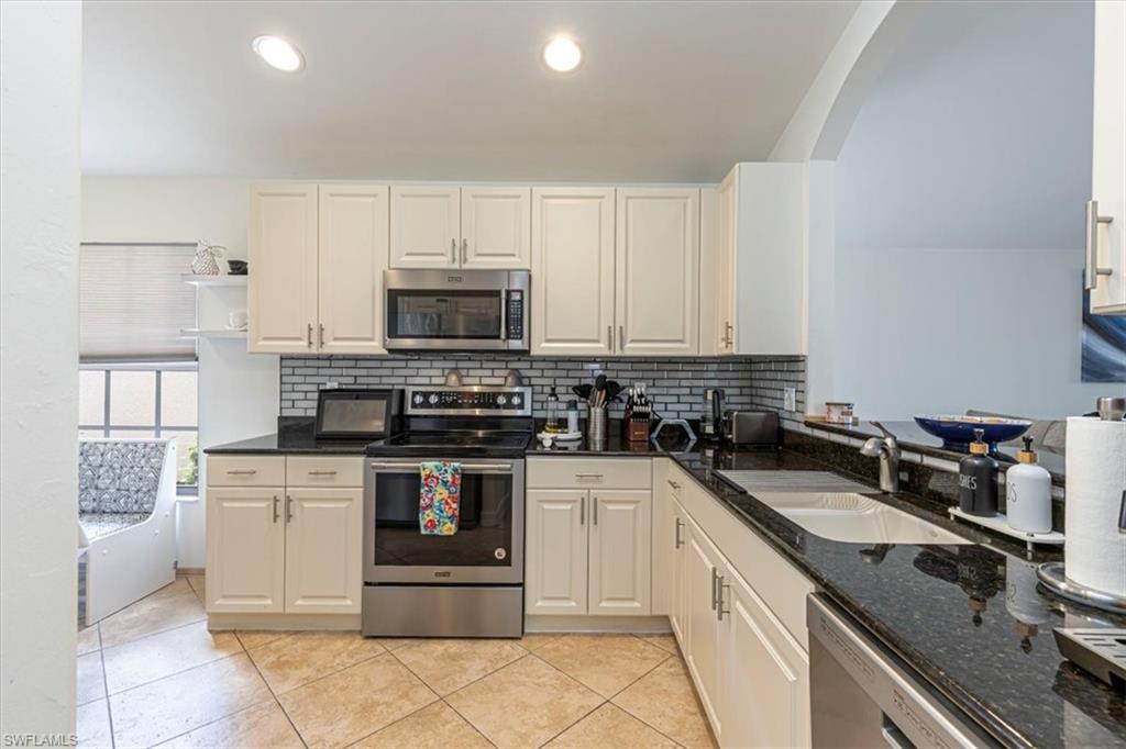 1630 Triangle Palm Terrace Naples, FL 34119 - Photo 7 of 24 a kitchen with stainless steel appliances granite countertop a stove and a sink