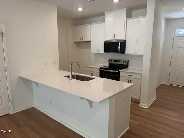 a kitchen with a sink a microwave and cabinets