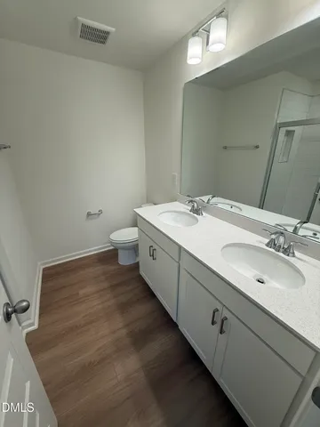 a spacious bathroom with a double vanity sink and a mirror