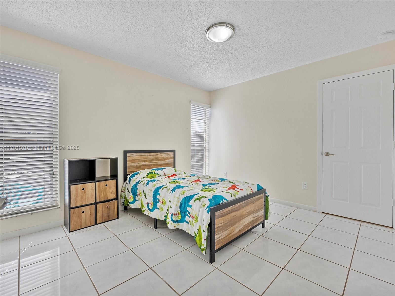 12744 Southwest 261st Terrace Homestead, FL 33032 - Photo 15 of 26 a bedroom with a bed and a window