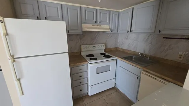 a white refrigerator freezer sitting inside of a kitchen