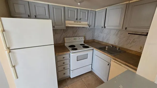 a kitchen with cabinets and white appliances
