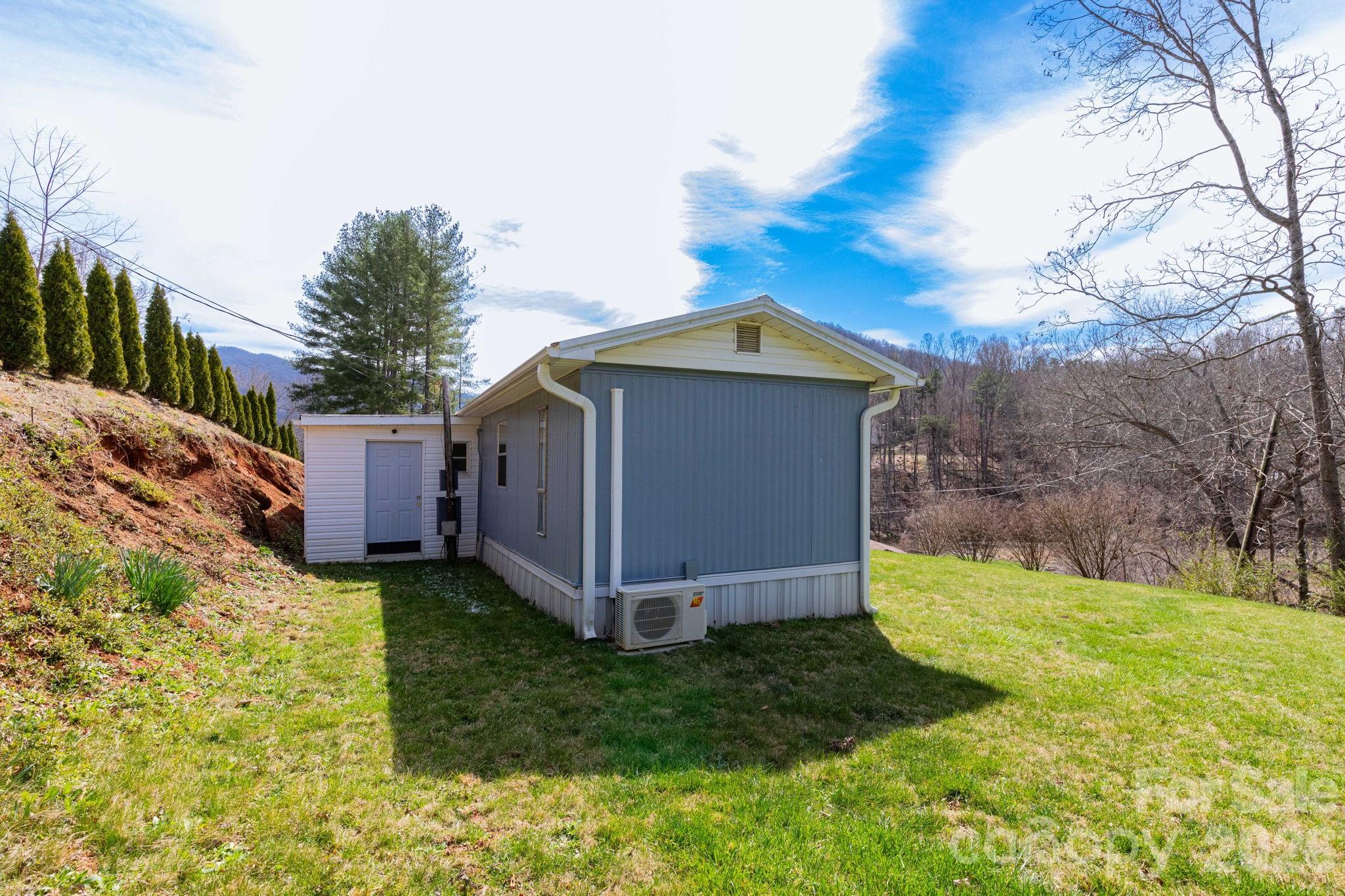 20 Ox Crk Road Weaverville, NC 28787 - Photo 5 of 22 a view of a wooden house with a big yard and large trees