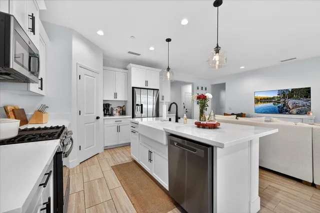 a kitchen with stainless steel appliances kitchen island a sink stove and cabinets