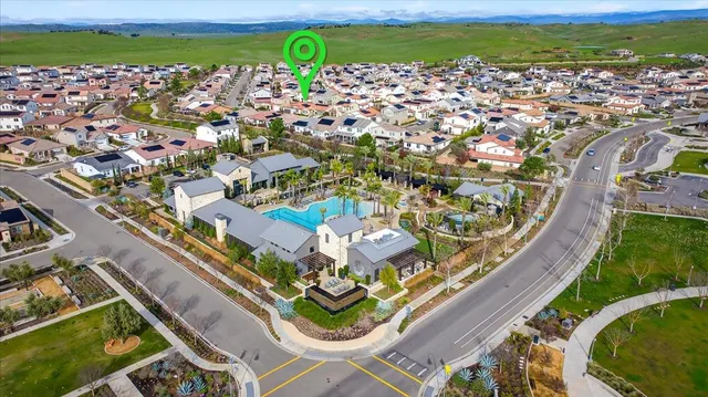 an aerial view of a swimming pool with outdoor seating and yard