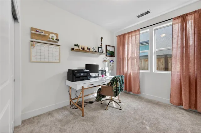 a view of a workspace with furniture and a window