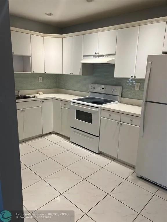 4131 Northwest 88th Avenue, Unit 206 Coral Springs, FL 33065 - Photo 2 of 41 a kitchen with a stove a sink and a refrigerator