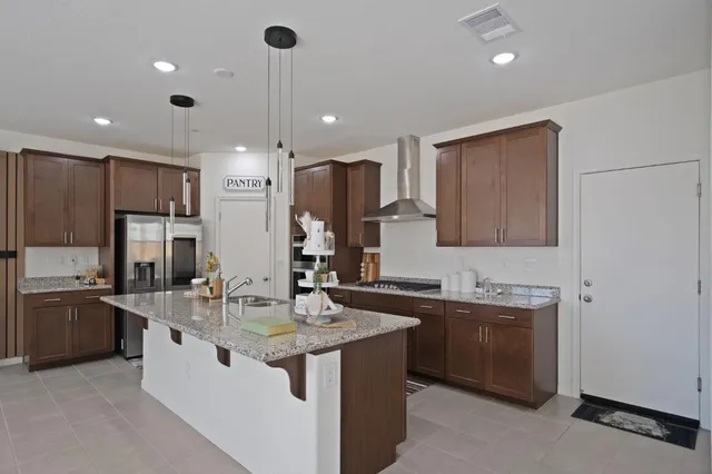 a kitchen with stainless steel appliances granite countertop a sink a stove and a refrigerator