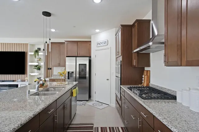 a kitchen with stainless steel appliances granite countertop a sink stove and refrigerator