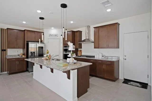a kitchen with stainless steel appliances granite countertop a sink a stove and a refrigerator