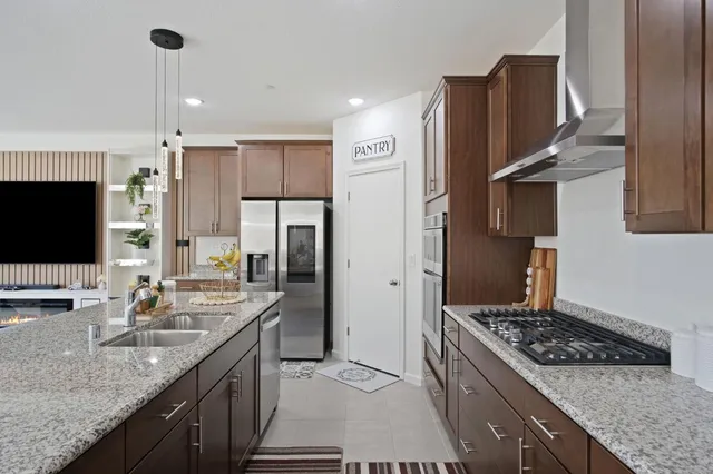 a kitchen with stainless steel appliances granite countertop a sink stove and refrigerator