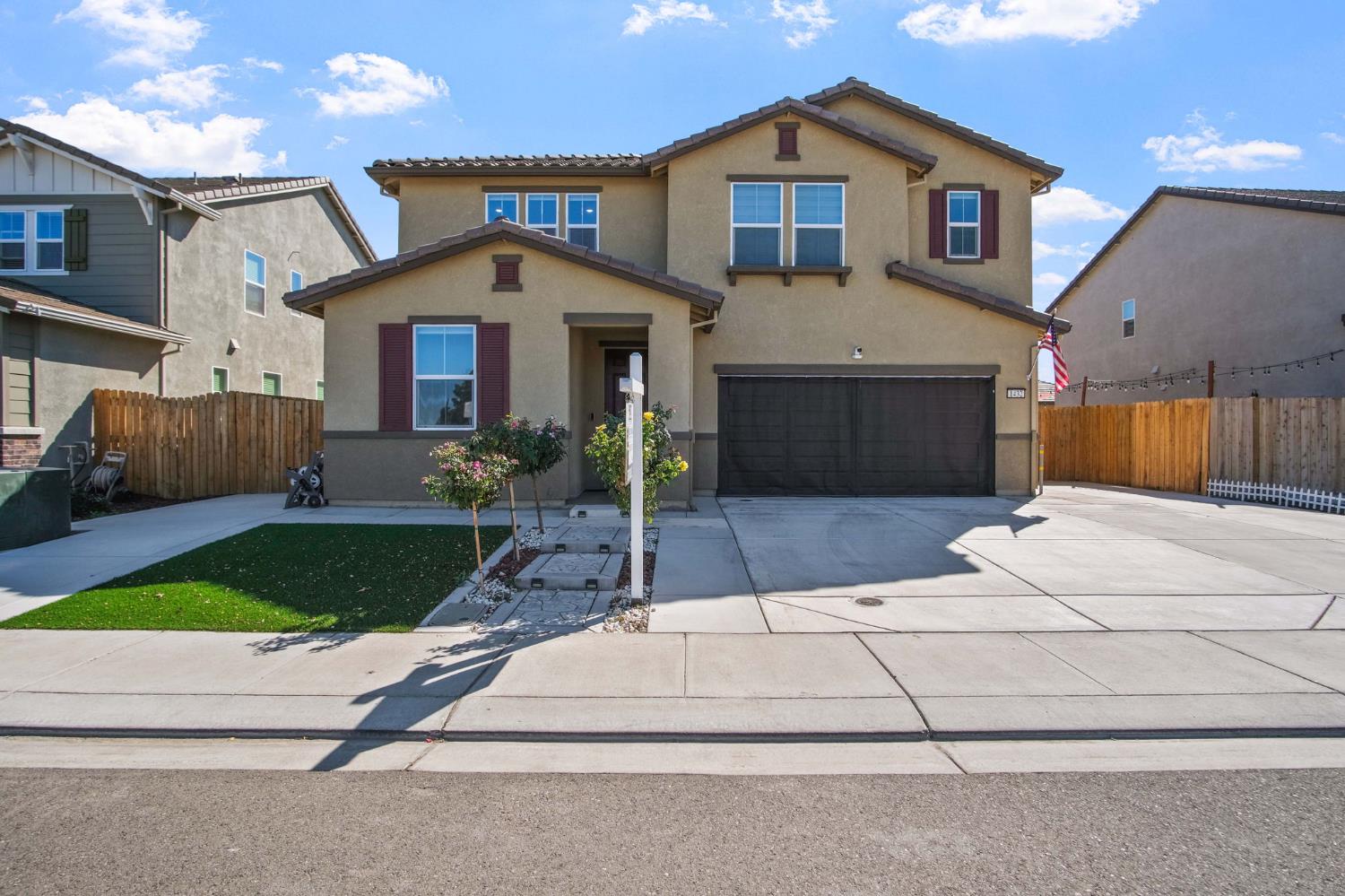 1432 Meridian Street Manteca, CA 95337 - Photo 2 of 42 a front view of a house with a yard and garage