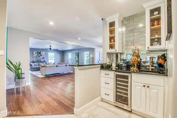 a kitchen with stainless steel appliances granite countertop a stove a sink dishwasher and a refrigerator with wooden floor