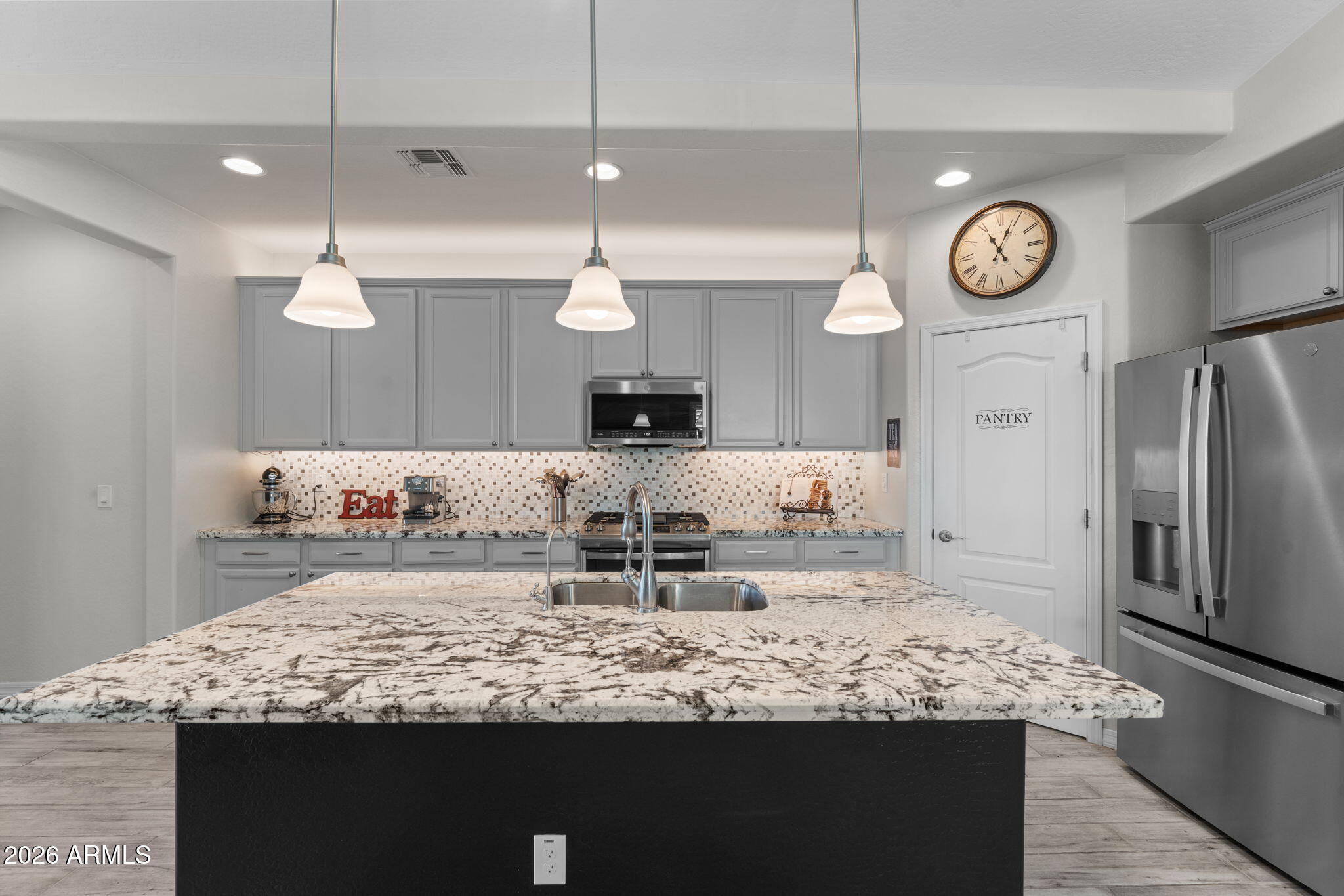 4320 Buffalo Ridge Wickenburg, AZ 85390 - Photo 7 of 57 a large kitchen with granite countertop a sink a refrigerator and a wooden floor