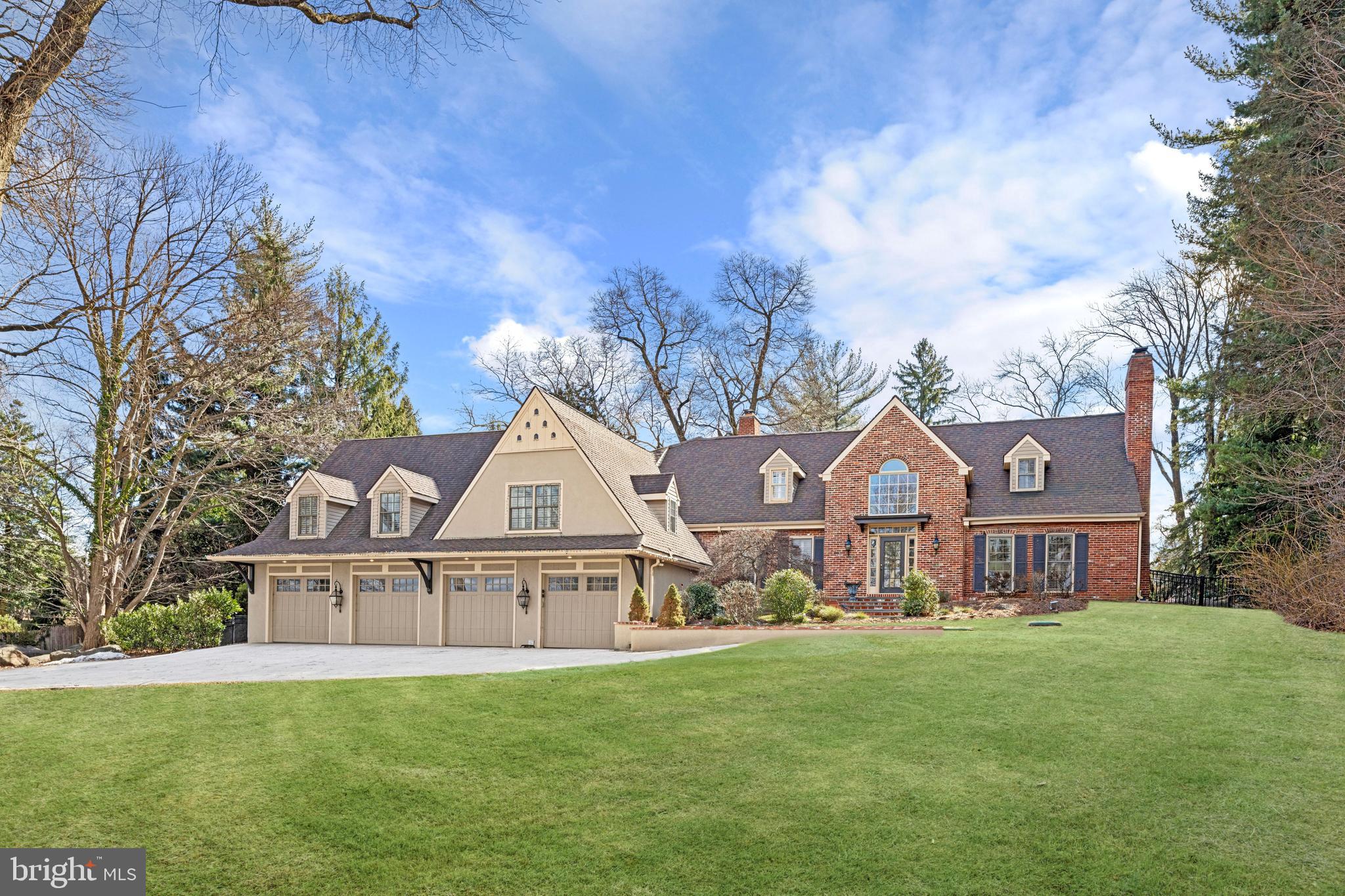 a view of a big house with a big yard and large trees