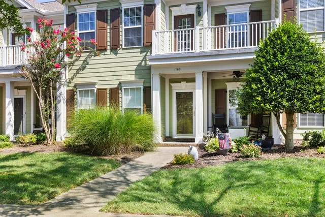 a view of a house with backyard garden and sitting area