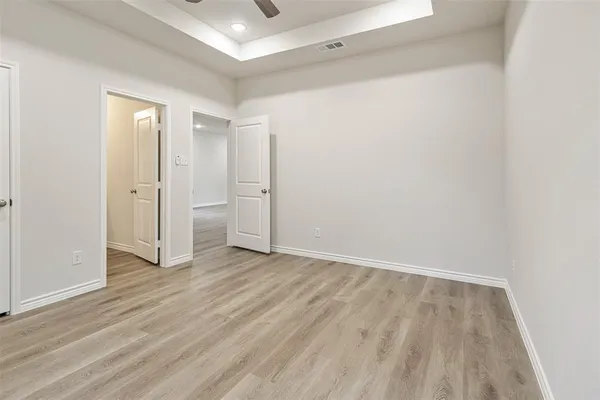 an empty room with wooden floor and closet
