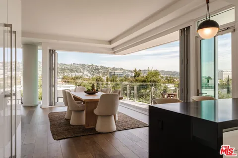 a view of a living room with furniture and floor to ceiling windows