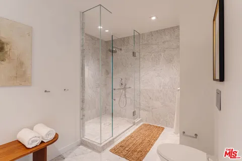 a bathroom with a shower a toilet and a sink