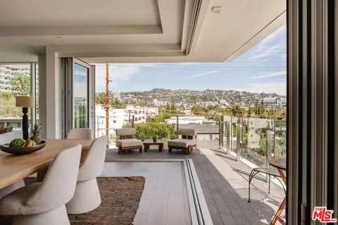 a view of a living room with furniture and floor to ceiling windows