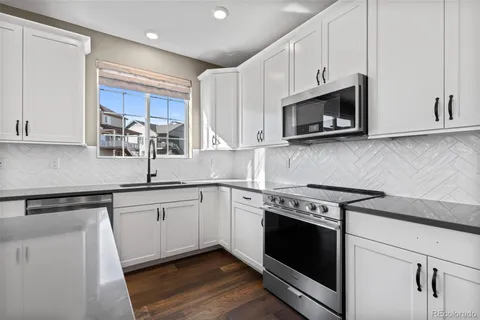 a kitchen with stainless steel appliances granite countertop a sink and a stove