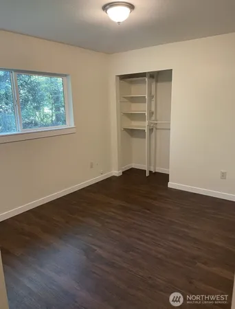 a view of a room with wooden floor and window