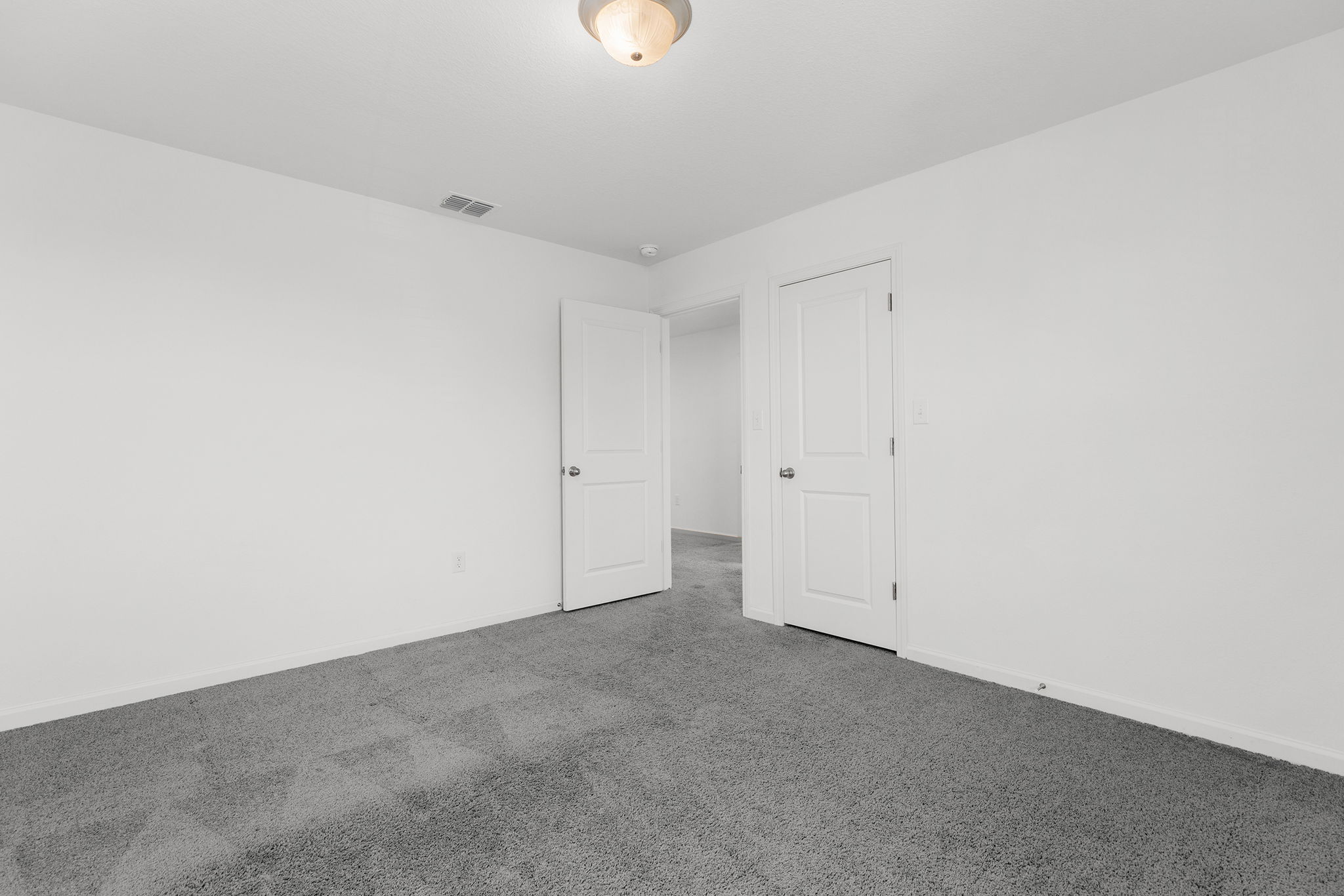 409 Line Of Fire Way Jarrell, TX 76537 - Photo 25 of 30 Room featuring a neutral color palette, painted walls, gray carpeting, semi-flush mount ceiling fixture, white trim, and open wall space.