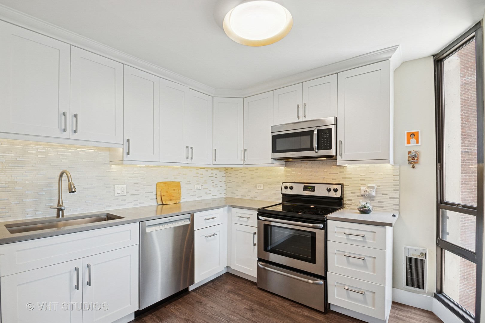 3150 North Sheridan Road, Unit 5A Chicago, IL 60657 - Photo 17 of 34 a kitchen with white cabinets stainless steel appliances and sink