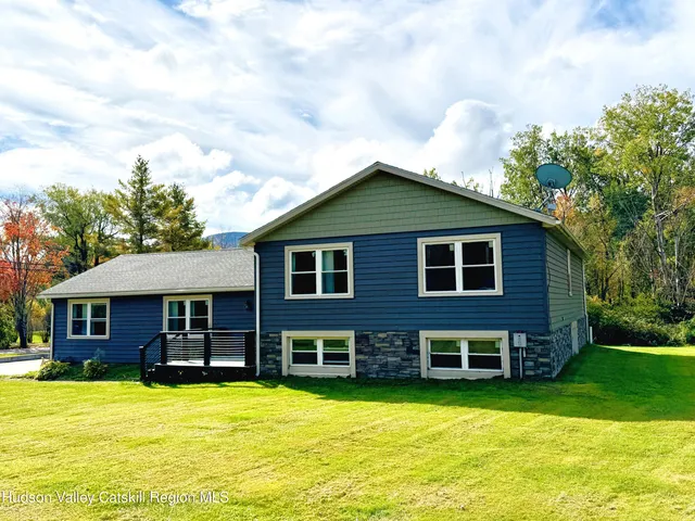 a view of a house with a swimming pool and a yard