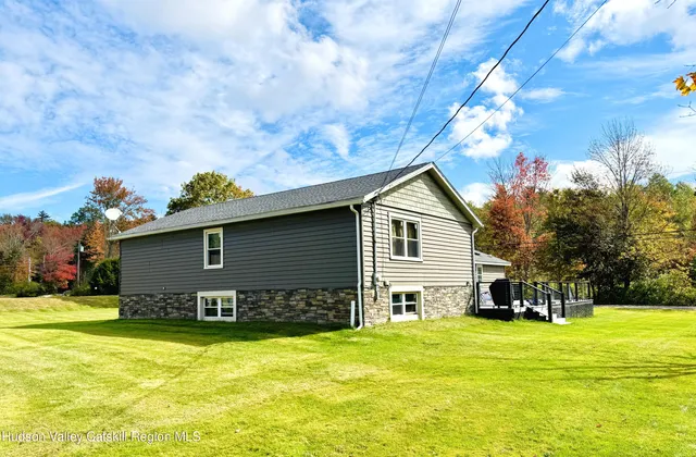 a front view of house with yard and trees in the background