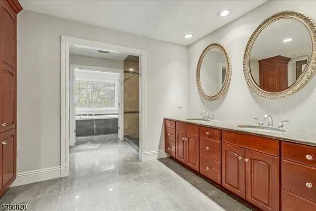 a bathroom with a granite countertop double vanity sink and a mirror