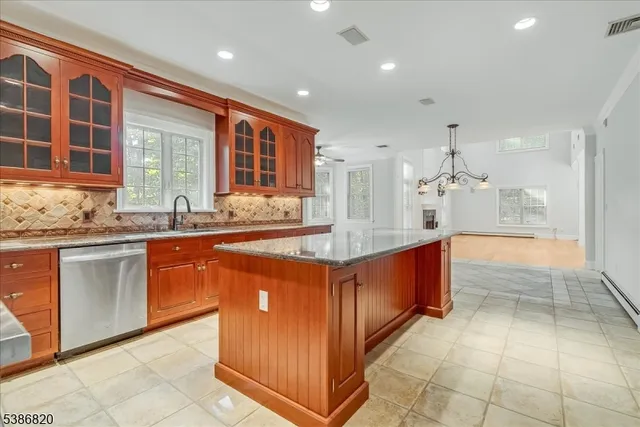 a large kitchen with kitchen island granite countertop a large counter top and stainless steel appliances