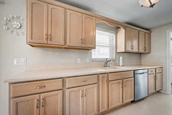 a kitchen with stainless steel appliances granite countertop a sink a stove a microwave and wooden cabinets