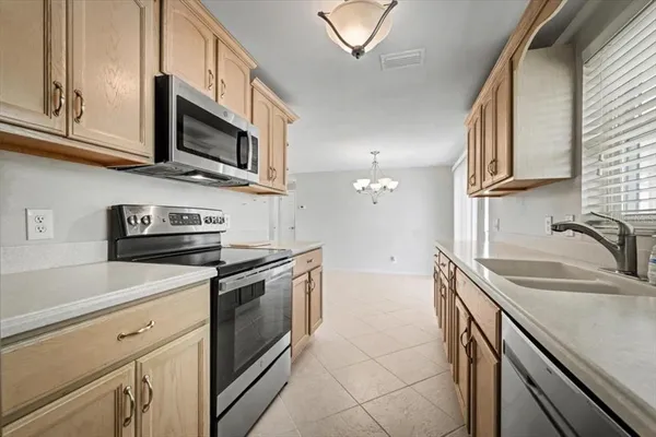 a kitchen with stainless steel appliances granite countertop a refrigerator a stove top oven a sink and dishwasher